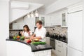 Young vegan family husband and wife cooking fresh food vegetables in kitchen