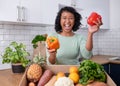 A young vegan woman gets excited about fresh fruit and veg box in kitchen Royalty Free Stock Photo