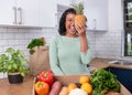 A young vegan woman holds up a pineapple with fruit and veg box delivery Royalty Free Stock Photo
