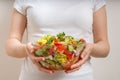 Young vegetarian woman holds vegetable salad in bowl Royalty Free Stock Photo