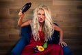 Young vegetarian woman sits on armchair on background of wooden wall Royalty Free Stock Photo