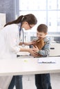 Young vet helping little boy with rabbit Royalty Free Stock Photo