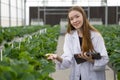 A young, vibrant woman dressed in a lab coat cradles a tablet. Her eyes, unwavering, brim with knowledge and determination as she