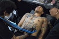 Young Vietnamese man is enduring pain as he gets a tattoo on his belly by Orang Utan Tattoo Studio