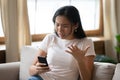 Young vietnamese woman feeling annoyed looking at smartphone screen. Royalty Free Stock Photo