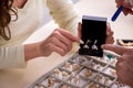 Young woman visiting old male jeweler