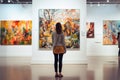 Young visitor admiring various paintings on the wall of an art gallery Royalty Free Stock Photo