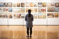 Young visitor admiring various paintings on the wall of an art gallery Royalty Free Stock Photo