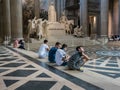 Young visitors sit on interior Pantheon steps in Paris