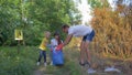 Young volunteer male and female with child girl cares about ecology environmental and collect plastic dregs in garbage