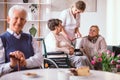 Young volunteer talking with elderly lady on the wheelchair in the retirement home Royalty Free Stock Photo