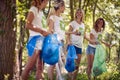 Young volunteers collecting garbage in park.Group of woman collecting plastic garbage in forest