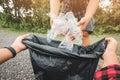 Young volunteers with garbage bags cleaning area in park, People and ecology.