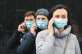 Young volunteers wearing face masks with mobile phones. World coronavirus pandemic