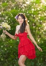 Young voluptuous brunette holding a wild flowers bouquet in a sunny day