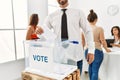 Young voter man smiling happy putting vote in voting box standing by ballot at electoral center Royalty Free Stock Photo