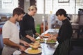 Young wait staff with fresh food in plates on kitchen counter Royalty Free Stock Photo