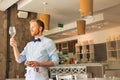 Young waiter looking at empty wineglass in restaurant