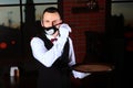 A young waiter removes a funny animated mask from his face.Preventing the spread of the virus. The end of the pandemic. The threat Royalty Free Stock Photo