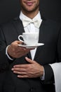 Young waiter in uniform serving hot coffee Royalty Free Stock Photo