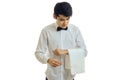 A young waiter in a white shirt tilted his head and keeps on hand a towel