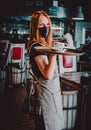 Young waitress standing in cafe. girl the waiter holds in bunches a tray with utensils. Restaurant service Royalty Free Stock Photo