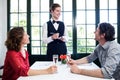 Young waitress taking an order from a couple Royalty Free Stock Photo