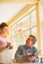 Young waitress taking order from mature customer at restaurant Royalty Free Stock Photo