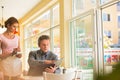 Young waitress taking order from mature customer at restaurant Royalty Free Stock Photo