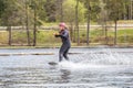 Young wakeboarder rides a wakeboard on the lake. Wakeboarding is cool, extreme sport Royalty Free Stock Photo