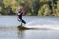 Young wakeboarder surfing along the river