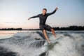 Young wakesurfer jumping on a wake board down the river Royalty Free Stock Photo