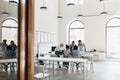 Young web-developers and other specialists discussing important questions at meeting. Indoor portrait from back of