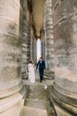 Young wedding couple posing between rows of antique building columns Royalty Free Stock Photo