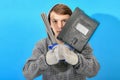Young welder with electrodes and welding shield on a blue background