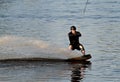 A young wet man wake boarding on a lake in summertime