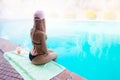 Young wet woman in black bikini and pink hat, sits with hands on Royalty Free Stock Photo