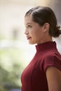 Young white businesswoman in maroon dress, side view, vertical