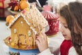 A young putting the finishing touches to a homemade gingerbread house