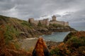 Young white Caucasian woman with long red hair stands against the background of the famous medieval castle la Latte of the fortres