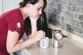 A young Caucasian woman looking very tired in the morning in her kitchen making a cup of tea for breakfast Royalty Free Stock Photo