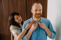 Young couple getting dressed while standing in bedroom together Royalty Free Stock Photo