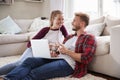 Young white couple sitting on the floor at home using laptop Royalty Free Stock Photo