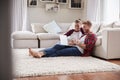 Young white couple sitting on the floor at home using laptop Royalty Free Stock Photo