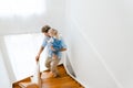 Young white father going down on stairs with little daughter at home