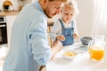 Young father and his little daughter having breakfast and using tablet computer at home Royalty Free Stock Photo