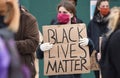 A young white female BLM protester with a sign that reads ` Black Lives Matter`