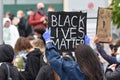 A young white female BLM protester with a sign that reads ` Black Lives Matter`