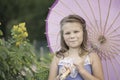 Young girl holding an umbrella in a garden Royalty Free Stock Photo