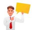 Young white guy in a gray shirt with a red tie points to a yellow empty rectangular speech bubble. The concept of personal opinion